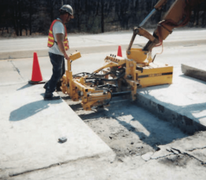 E-Z Drill concrete dowel pin drill mounted to excavator for full depth repair